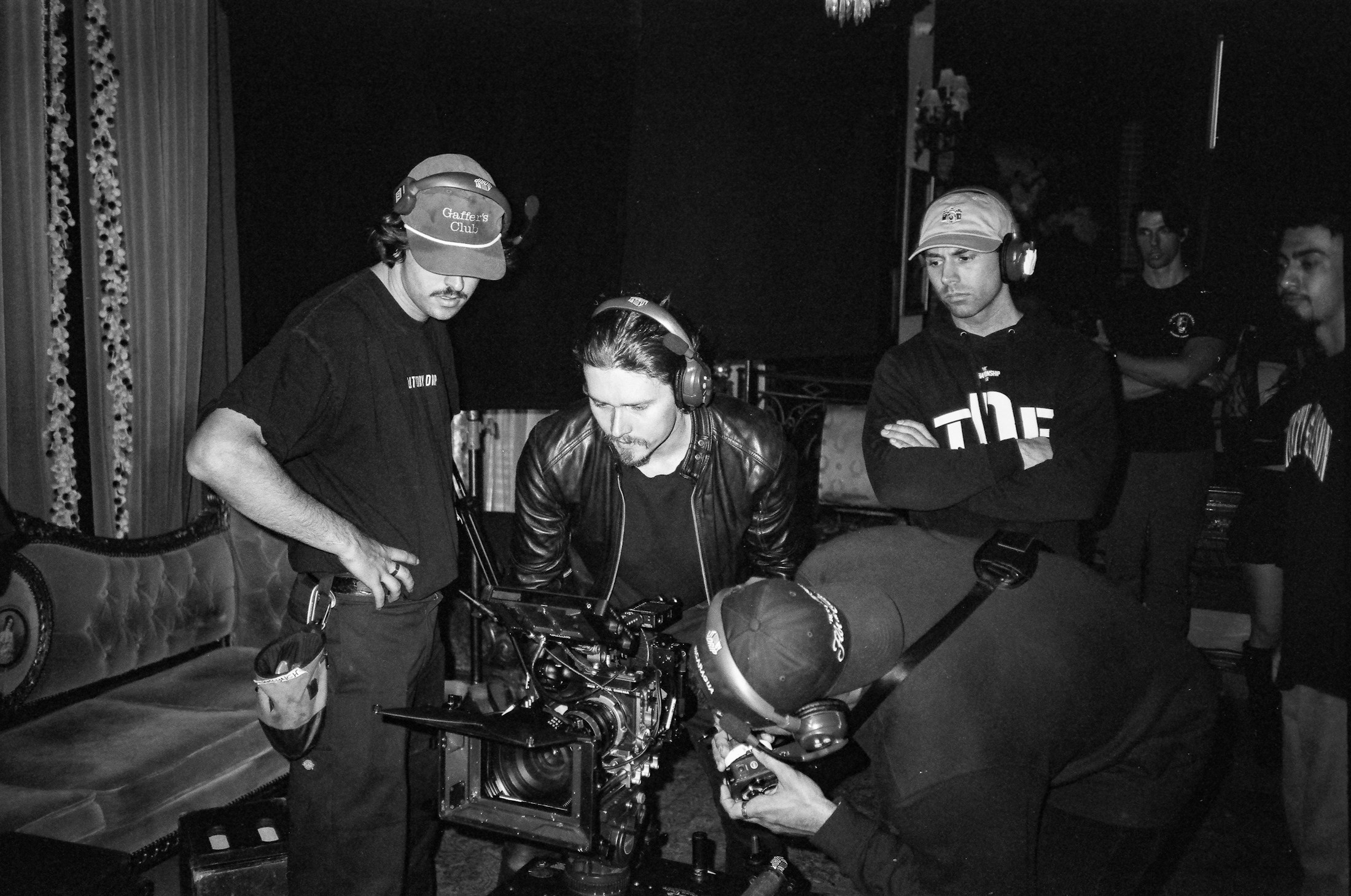 Film crew collaborating around a cinema camera on set
